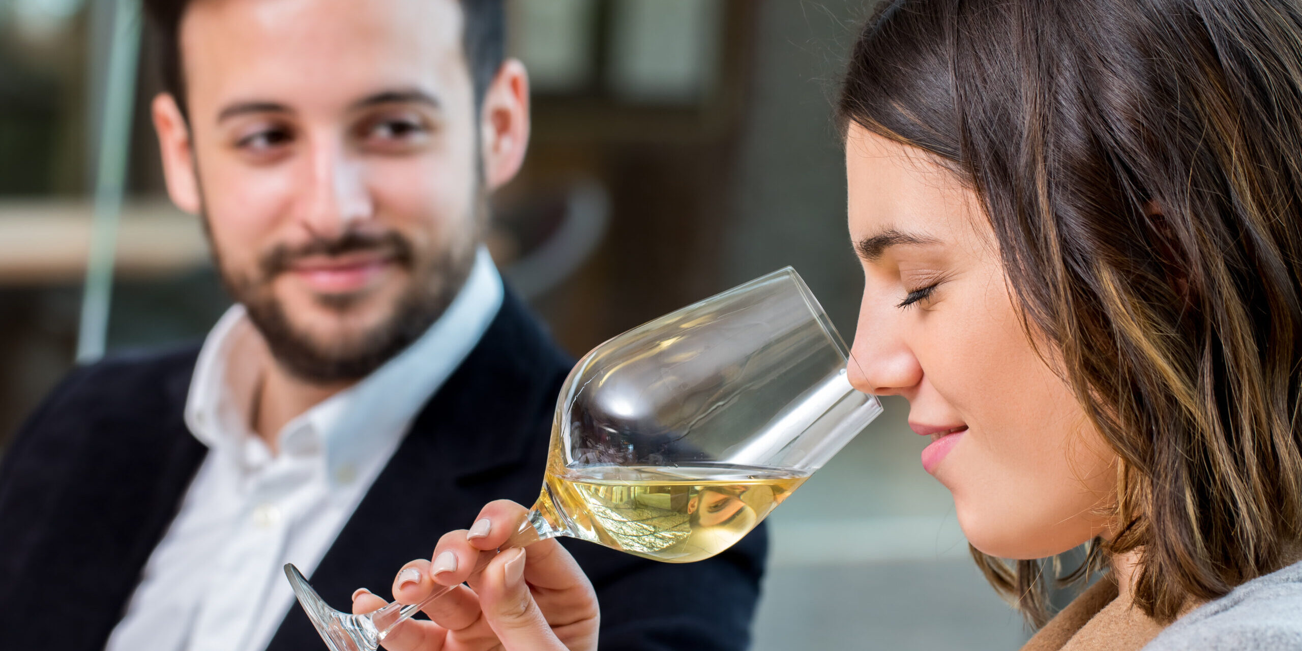 Woman smelling white wine at tasting.